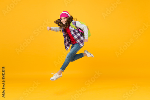 sense of freedom. childhood activity. little girl listen music in headset with backpack. back to school. small schoolgirl running to school. hurry up its holiday time. child being late. energy jump