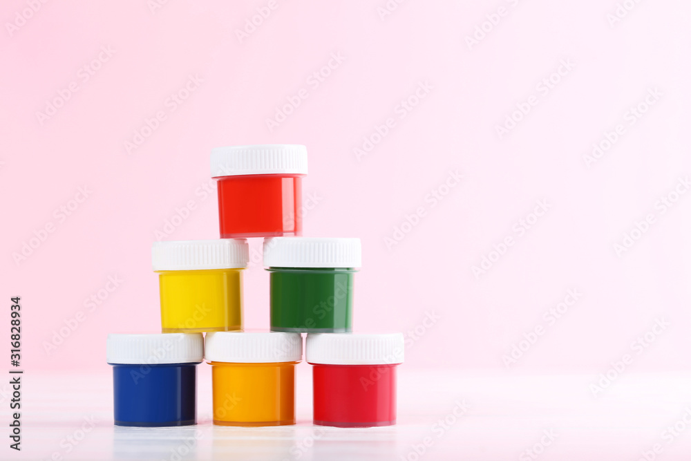 Colorful gouache paints on pink background Colorful gouache paints on pink background