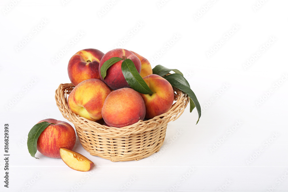 Fresh peaches in basket on white wooden table Fresh peaches in basket on white wooden table