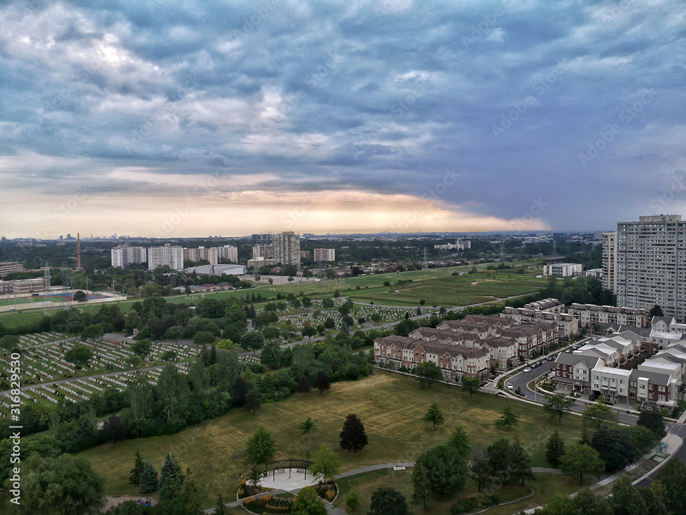 Beautiful morning evening sky clouds in Toronto city, Canada. Landscape aerial top view with urban streets and parks. Twilight in Canadian at sunrise or sunset. Residential area in large city.