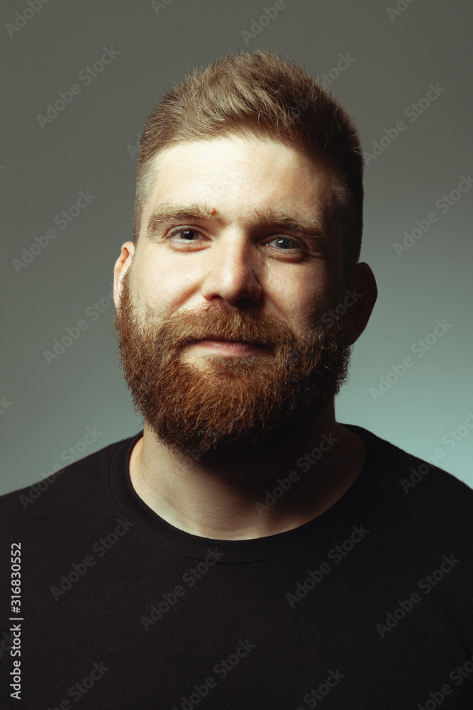 Obraz premium Fabulous at any age. Close up portrait of sweet charismatic muscular 30-year-old man with red hair posing over light gray background. Perfect haircut. Rocker, biker, hipster style. Studio shot