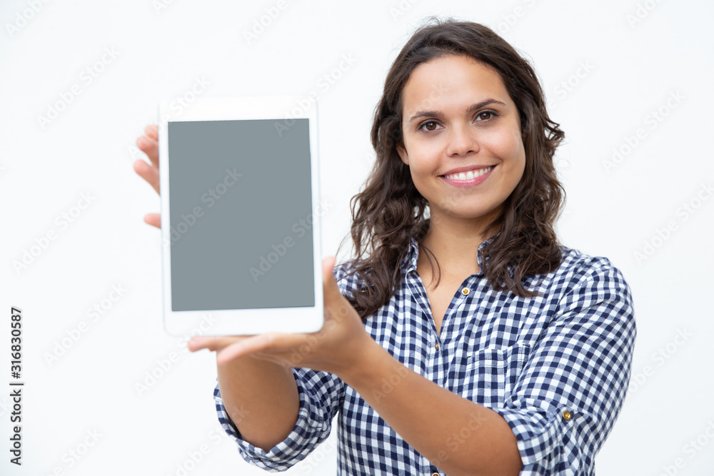 Content woman showing digital tablet. Beautiful happy young woman showing tablet computer with blank screen and smiling at camera. Advertisement concept Content woman showing digital tablet. Beautiful happy young woman showing tablet computer with blank screen and smiling at camera. Advertisement concept