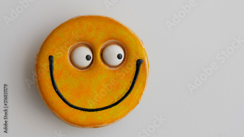 Smily face magnet on a fridge.