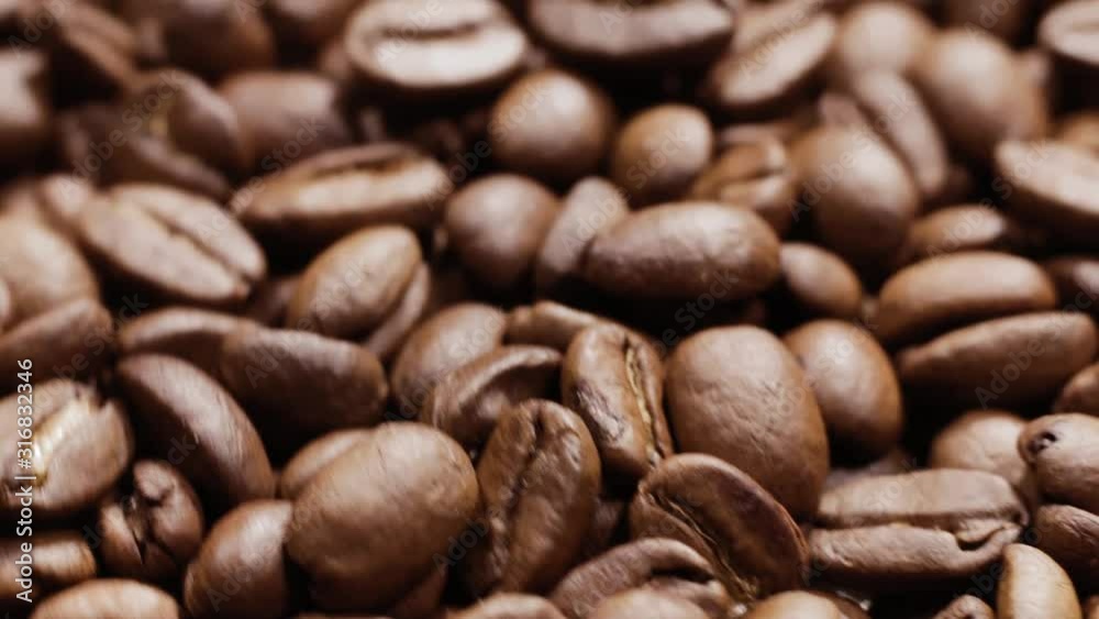 Detail of rotating heap of dark coffee beans Detail of rotating heap of dark coffee beans