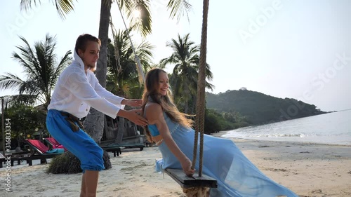 Married and pregnant, Couple in love spend time at swing on the sand tropical beach of Thailand island