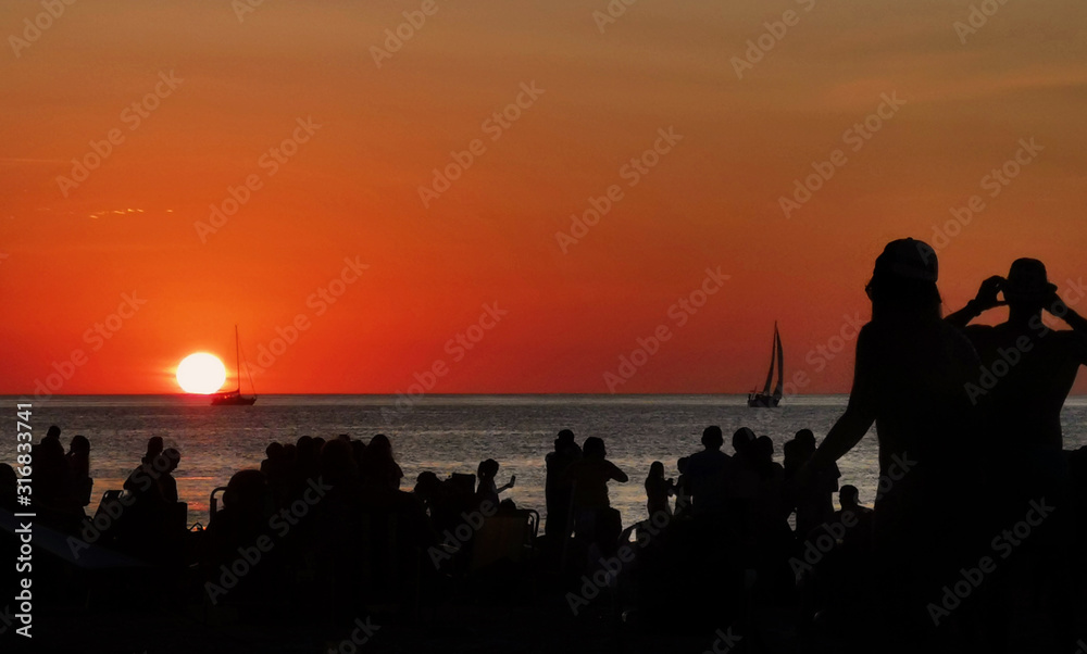 silhouette of people on the beach at sunset