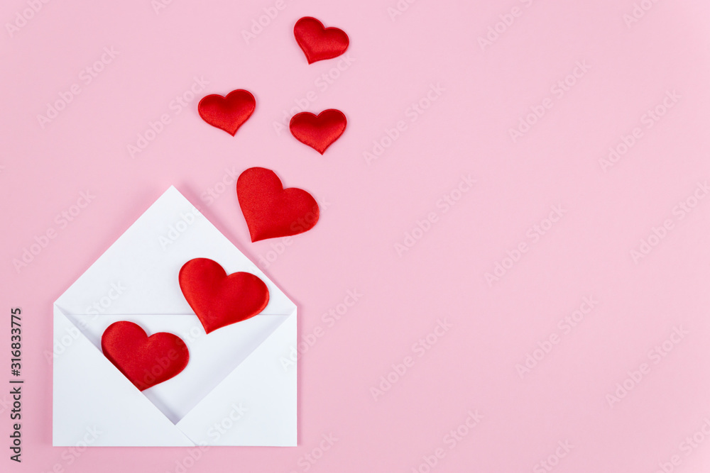 red hearts spill out of a white paper envelope
