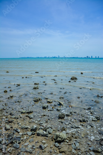 Stone courtyard on the public beach,Beautiful seascape with natural stone yard on beach against cloudy sky,Rocky shore at the seacoast with seascape and blue sky,