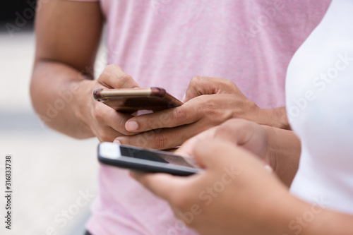 Closeup shot of hands texting on modern phones. Cropped shot of young people using smartphones. Technology concept