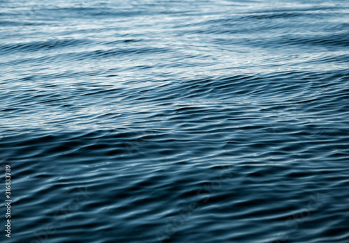 Water texture of deep navy color. Natural background of sea, lake or river surface