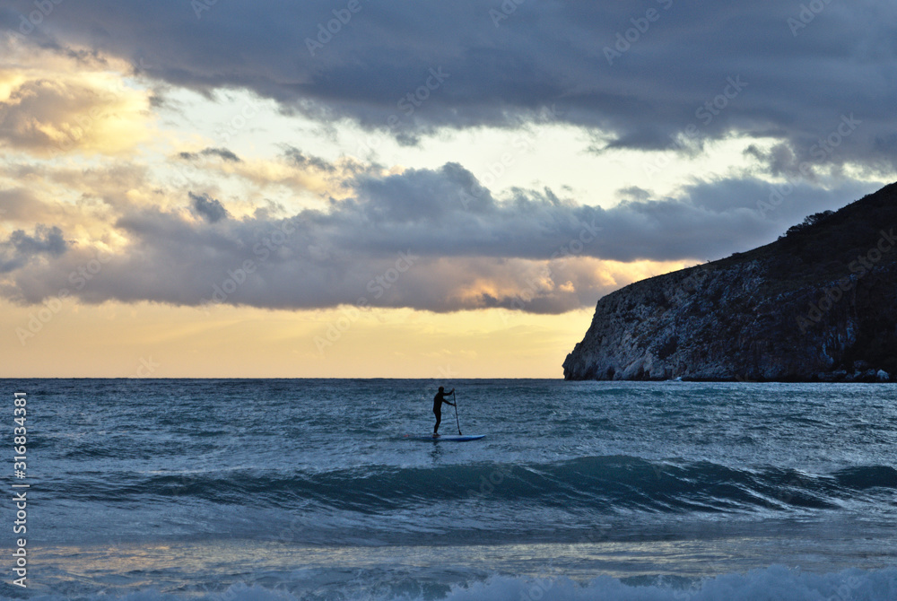 men surfing at sunset
