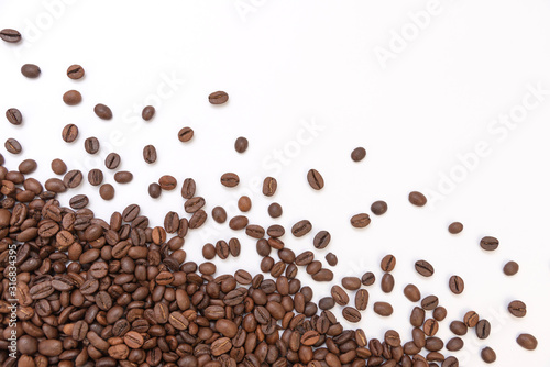 fresh roasted coffee beans sprinkled on a white background