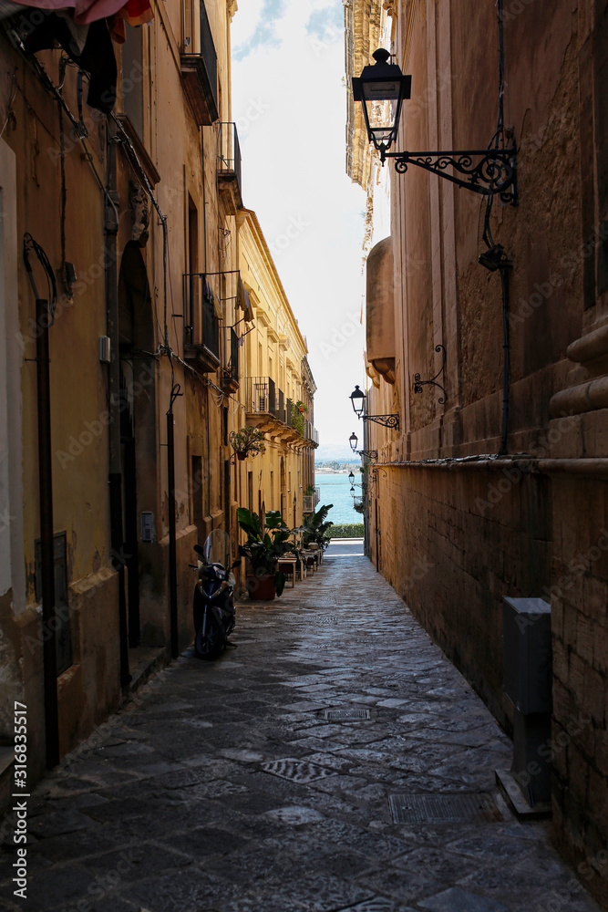 Fototapeta one of the charming, narrow street in Ortigia, oldest part of the beautiful baroque city of Syracuse in Sicily, Italy