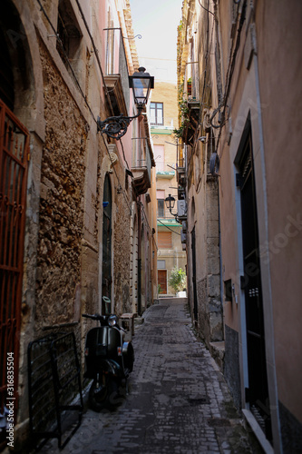 one of the charming, narrow street in Ortigia, oldest part of the beautiful baroque city of Syracuse in Sicily, Italy