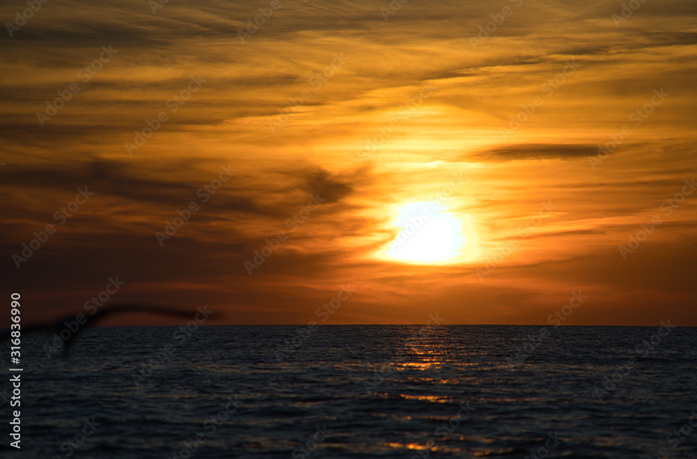 Wellen und Meer mit romantischen Sonnenuntergang und brennenden atemberaubenden Himmel am Horizont 
