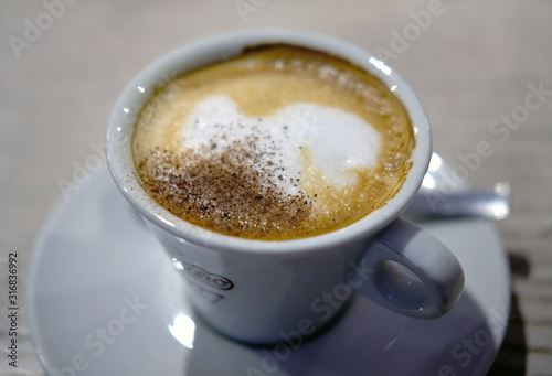 White Coffee Cup Cappuccino on on a plate with a spoon