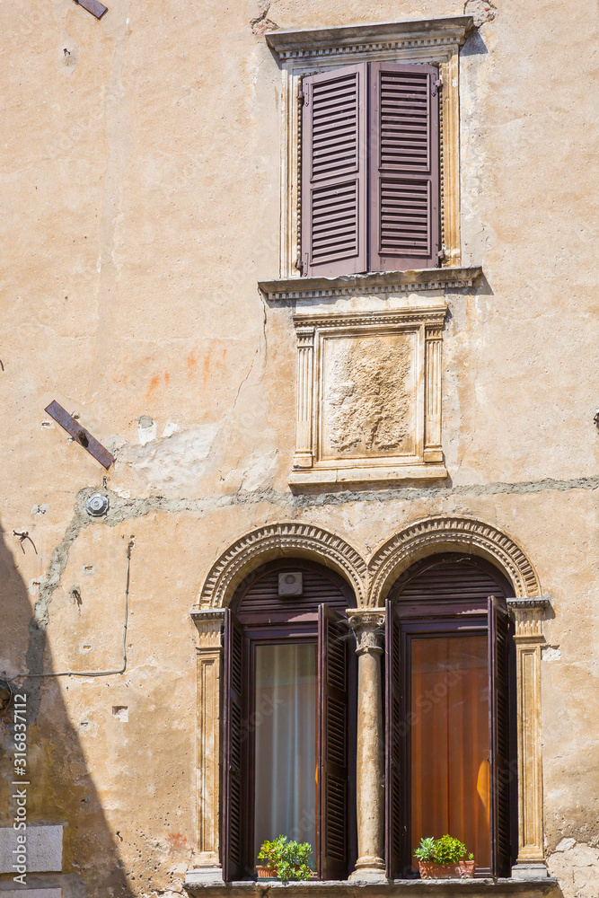 Obraz premium Old house facade, big windows, open shutters. in popular touristic village Garda
