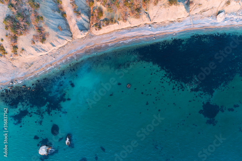 Aerial view of sandy beach with waves and clear ocean water. Drone photo.
