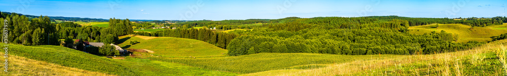 Panoramic view of the undulating landscape with meadow and trees in autumn colors.