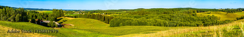 Panoramic view of the undulating landscape with meadow and trees in autumn colors.