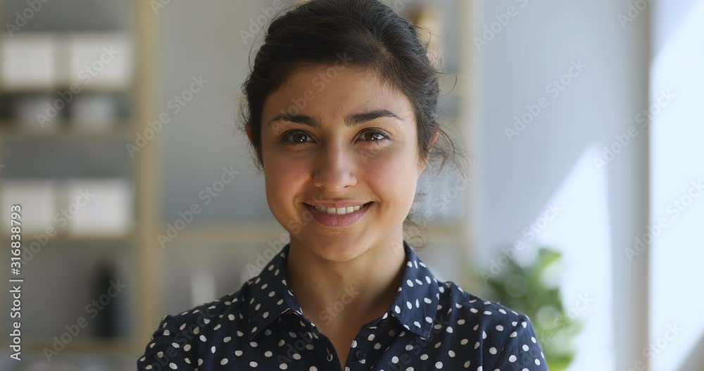 Smiling indian woman pretty face looking at camera, closeup portrait