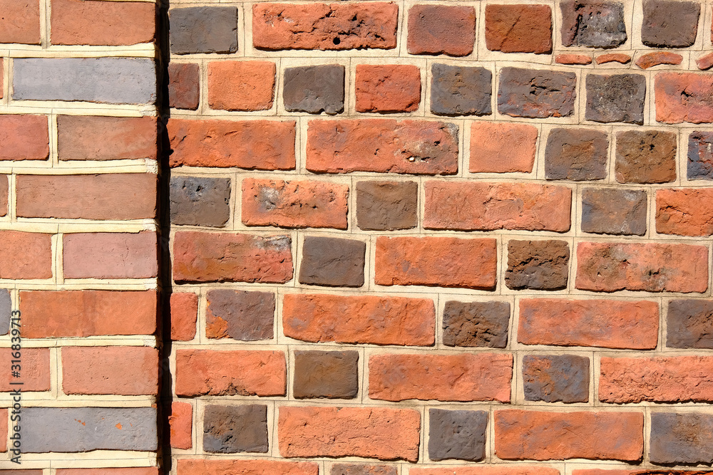 Fototapeta premium Red and gray bricks old vintage wall. Abstract architectural background for design.
