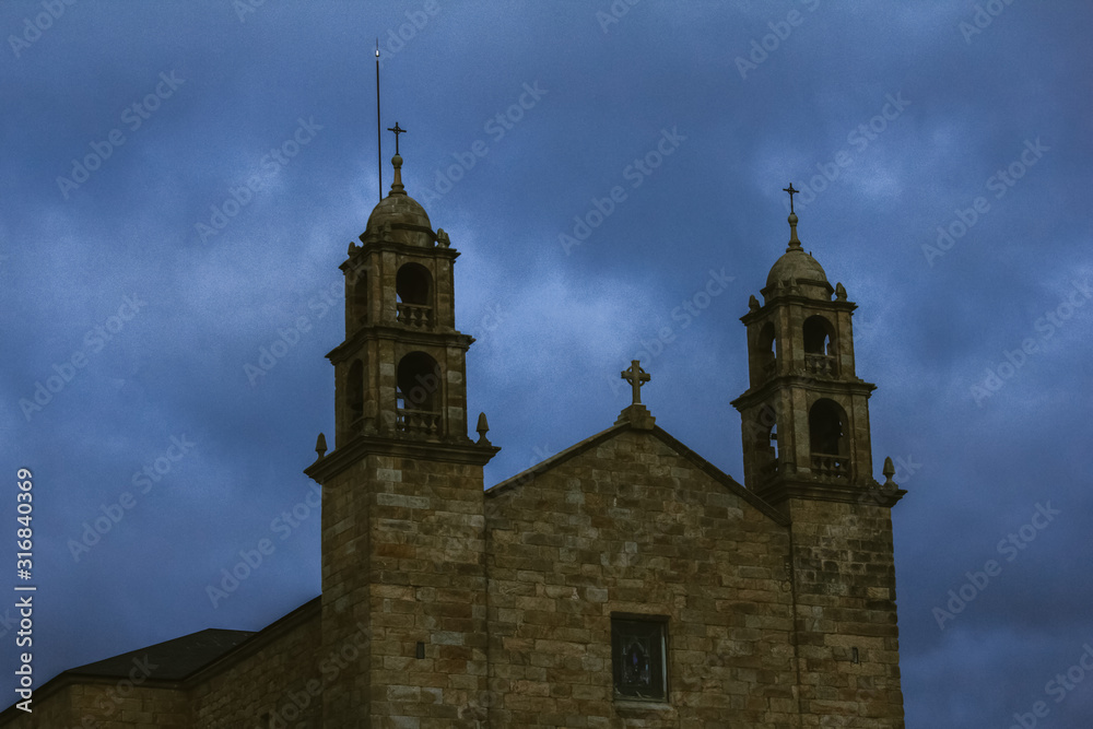 The Virxe da Barca sanctuary, a church located in Muxía, Spain.Church on the coast of Atlantic Ocean at the end of the Santiago path. Twilight, view of the church. Temple against a dramatic sky.
