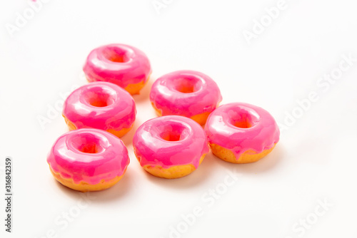 Group of donuts with pink icing on a white background. High-calorie food. Dessert. National Doughnut Day, Sweetest Day. 