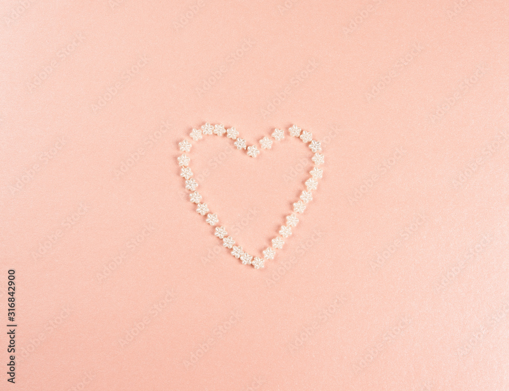 the heart is lined with beads of flowers white on a peach pink background