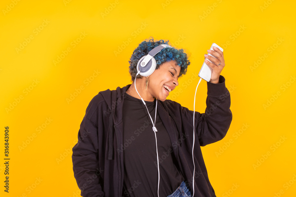 Fototapeta premium young girl dancing isolated with headphones in color background
