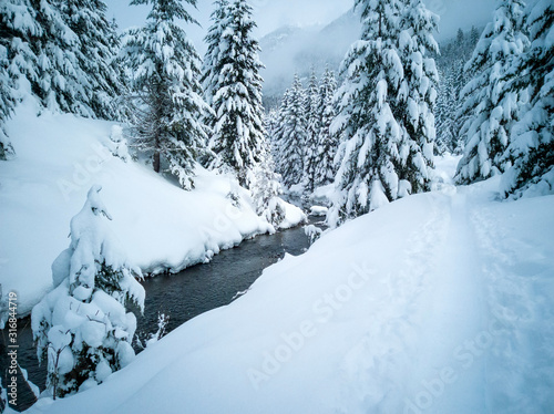 Snow covered frozen beautiful Gold Creek Pond with snow covered trees and trail during the winter in the Alpine Lakes Wilderness in Kittitas county Washington State © Marc Sanchez
