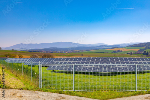 Solar panel, alternative electricity source - concept of sustainable resour ces.Summer landscape.