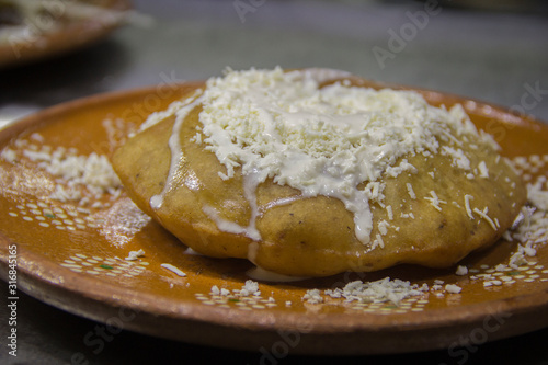 Fried mexican snack and fresh crumbled cheese