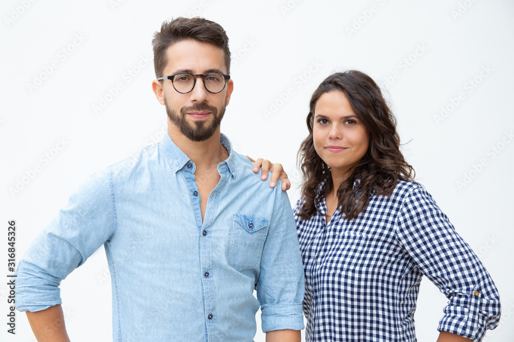 Young couple looking at camera. Attractive young man and woman standing together and looking at camera on white background. Relationship concept Young couple looking at camera. Attractive young man and woman standing together and looking at camera on white background. Relationship concept