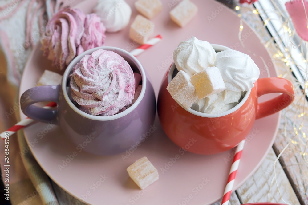 Two cups of coffee with meringues and marshmallows, Turkish delight on a plate, hearts, illumination, against the background of a window, homeliness, Valentine's day Two cups of coffee with meringues and marshmallows, Turkish delight on a plate, hearts, illumination, against the background of a window, homeliness, Valentine's day