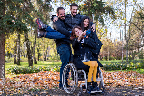 Disabled girl taking selfie with her friends in the park