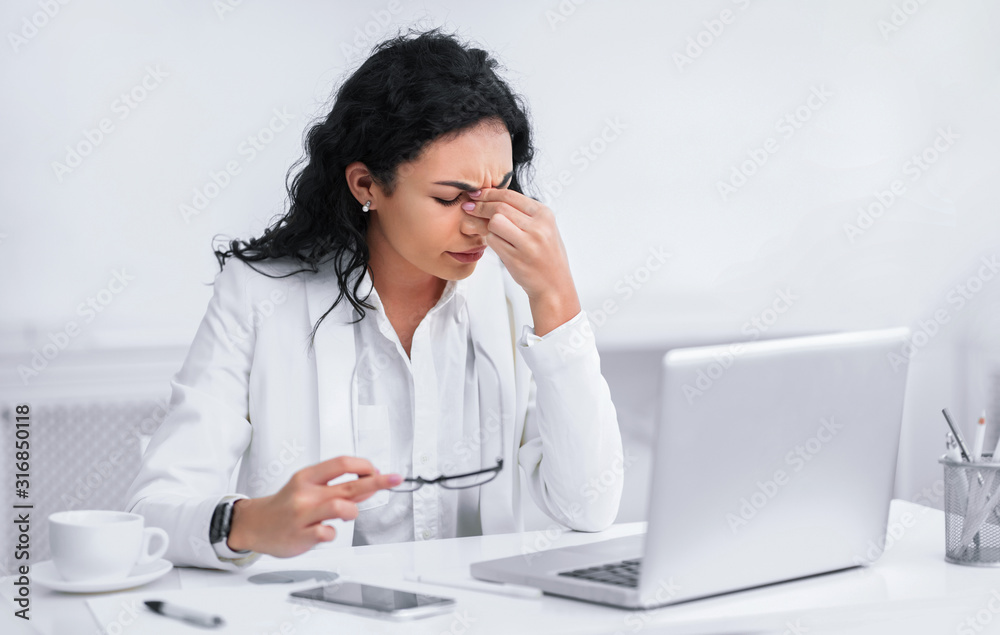 Tired mexican teacher massaging nose and eyes