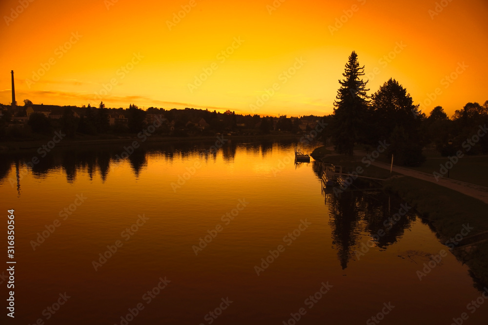  Landscape with river in front flowing  at sunset sky