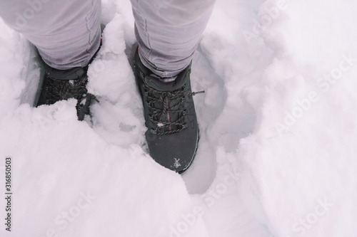 woman in winter boots walking through the snow