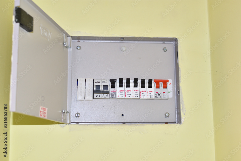 Voltage switchboard with circuit breakers. A finger is about to switch