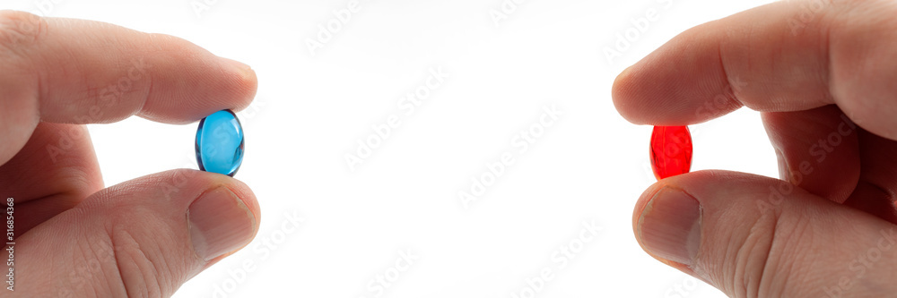 Choice between reality and fantasy, knowledge vs ignorance and popular internet meme concept with hand holding red and blue pill isolated on white background with copy space