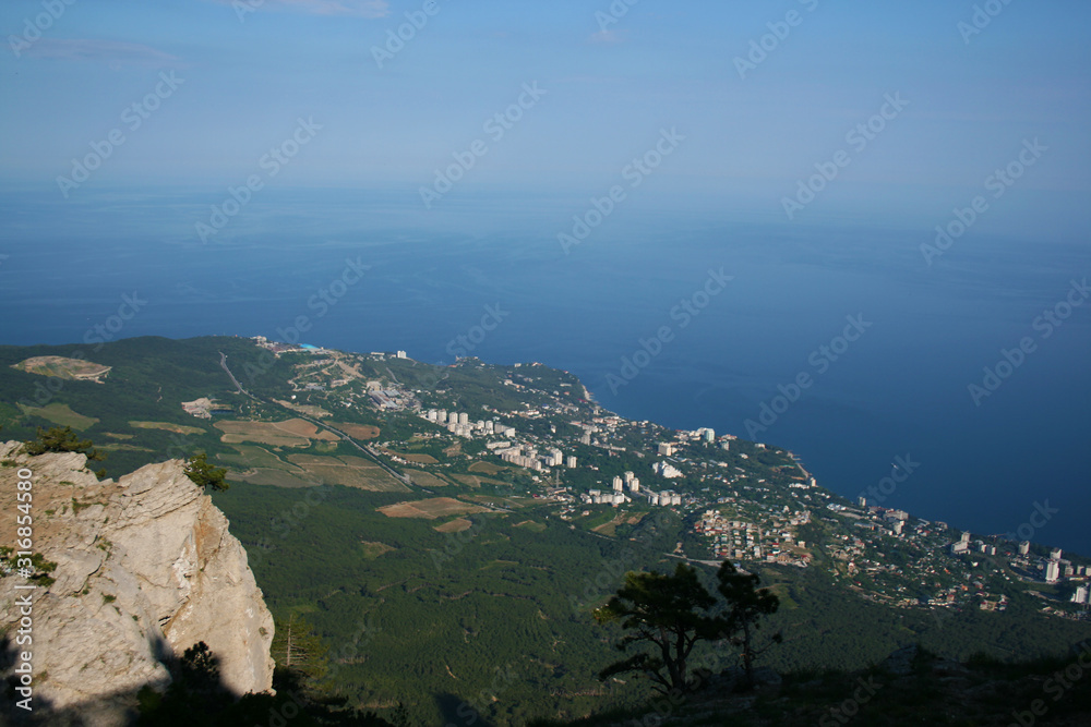 Alpine landscape. View from a high mountain to a small town by the sea