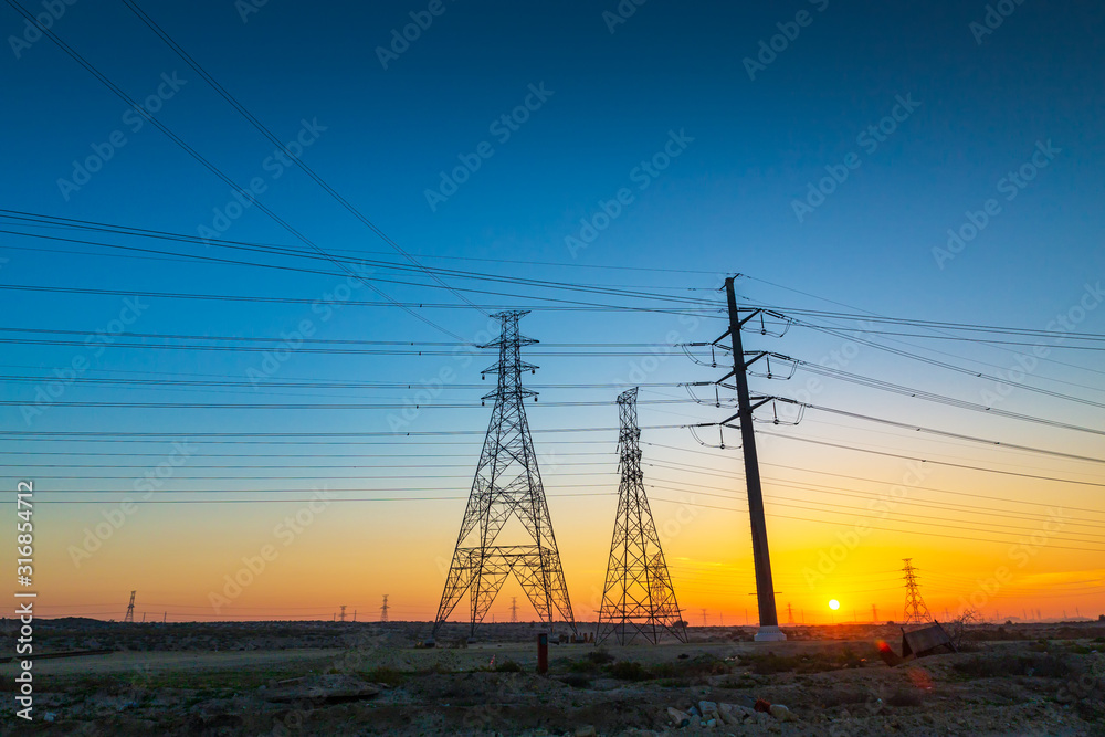 High voltage electric tower on sunrise time and sky on sunrise time background.Jubail Highway-Saudi Arabia.