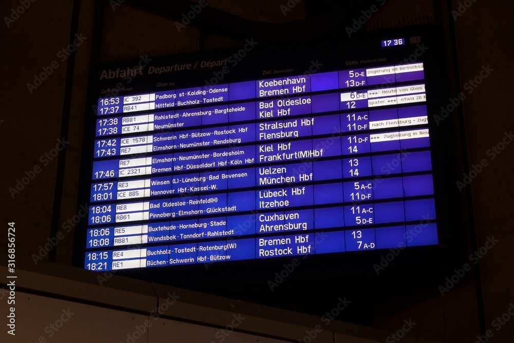 Fototapeta premium Digital display board for the departure of trains to various German cities at Hamburg main station, dark background