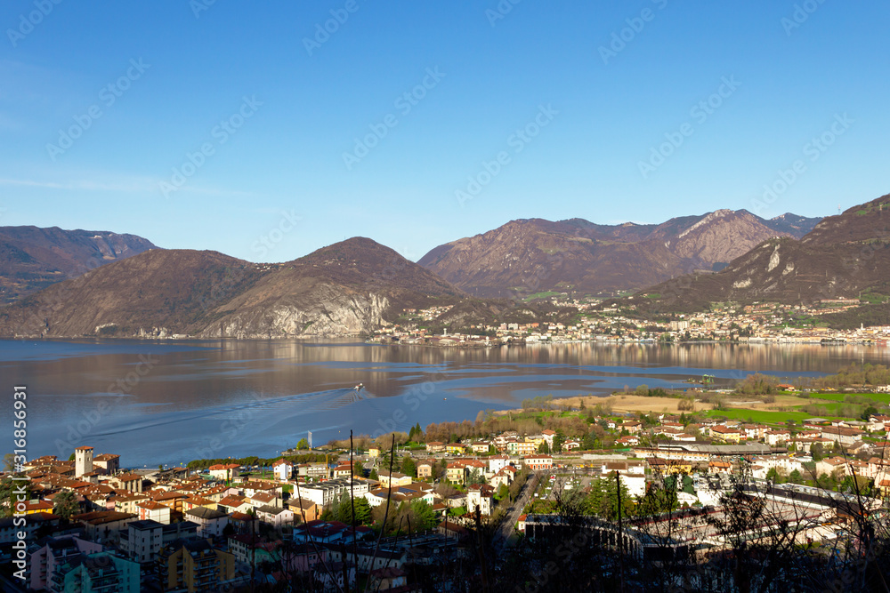 Cityscape of a little Italian village with Iseo Lake in the middle seen from above