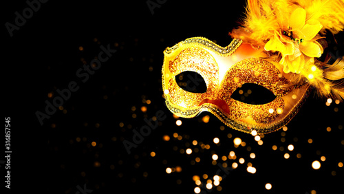 Golden Carnival mask on black background. Mardi Gras concept. Copy space