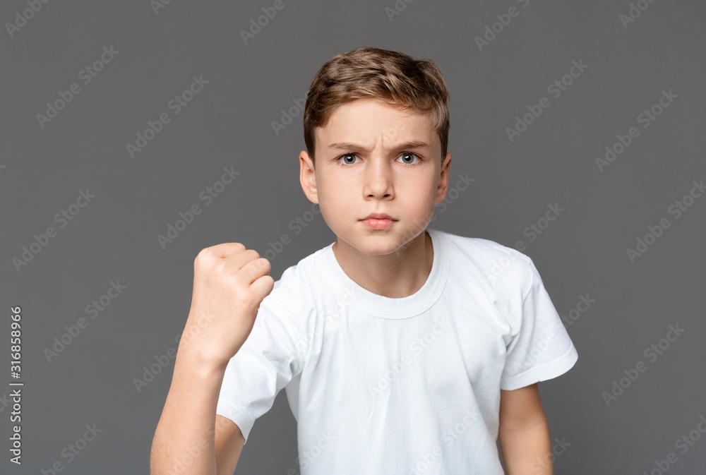 Furious teenager fisting at camera with angry expression Furious teenager fisting at camera with angry expression