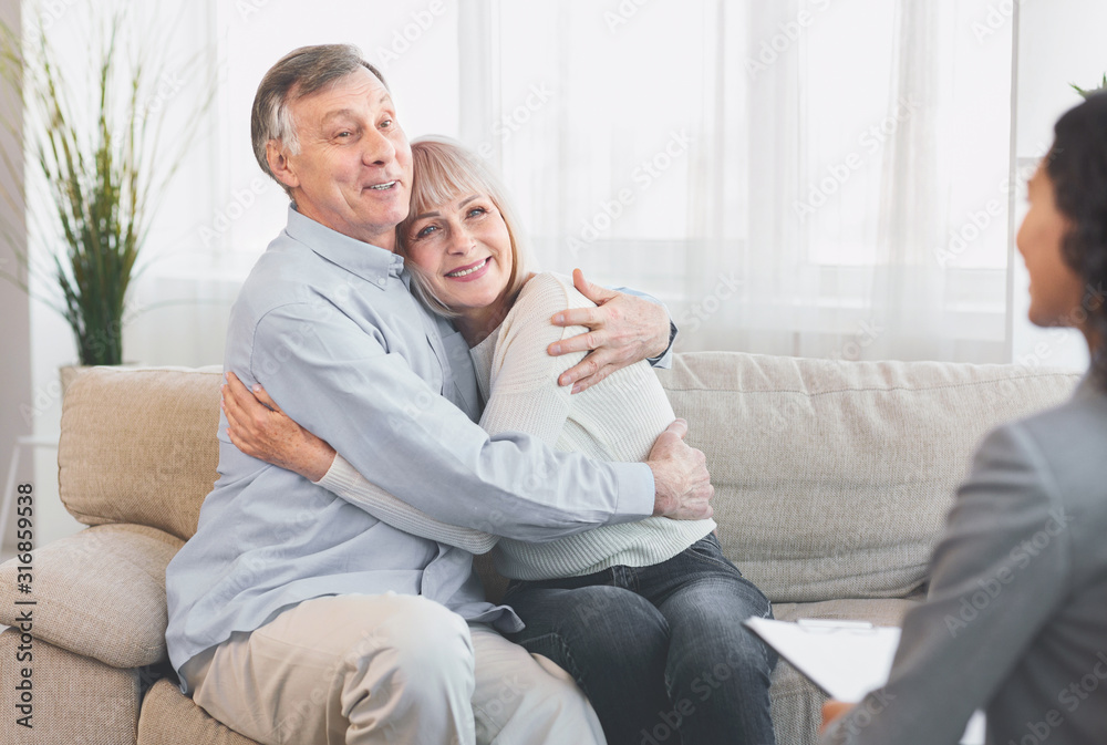 Happy mature couple hugging after successful therapy