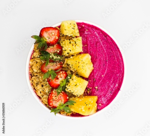 Aerial Shot of a Red Smoothie Bowl with Strawberries, Pineapple, and Nuts With A White Background
