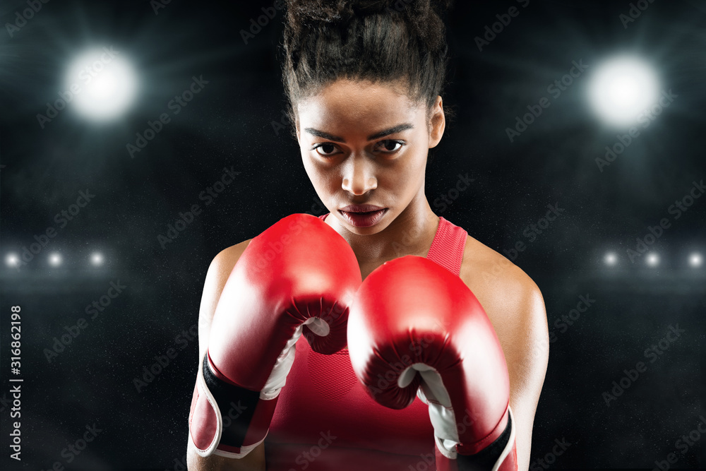 Confident black woman boxer standing in pose, ready to fight
